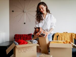 Woman packing clothes into donation boxes while preparing for a move in Westchase, Tampa