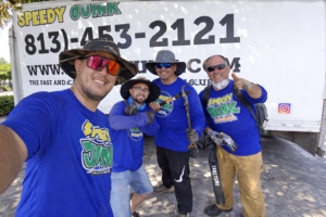 Speedy Hauling junk removal team standing in front of branded truck in Tampa Florida