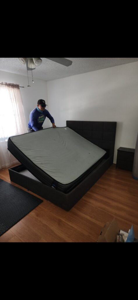 Speedy Hauling team removing a mattress from a bed frame during a junk removal job in Tampa Florida
